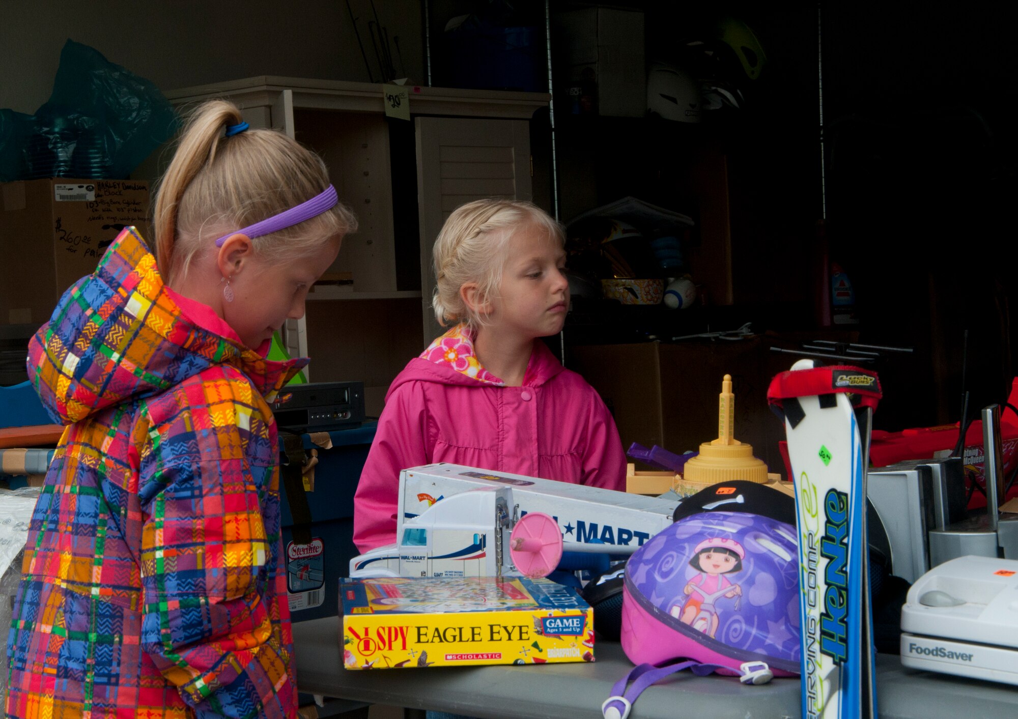 Isabelle and Claire Skrettingland, Cheyenne residents, browse through a toy selection during the F.E. Warren Air Force Base Yard Sale June 7, 2014. (U.S. Air Force photo by Airman 1st Class Jason Wiese)