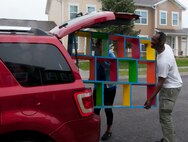 Airman 1st Class Eli Daniel, 90th Security Forces Squadron, and his wife Aleysa put a decorative shelf in their vehicle after buying it at the F.E. Warren Air Force Base Yard Sale June 7, 2014. Eli Daniel said the shelf will go well in his one-year-old son Avery's circus-themed bedroom. (U.S. Air Force photo by Airman 1st Class Jason Wiese)