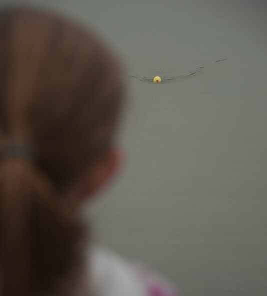 140607-F-GZ967-006 Sierra, 7, daughter of Master Sgt. Bill Utley, 90th Logistics Readiness Squadron, slowly reels in her line June 7 at the Warren Base Lakes during Wyoming’s Free Fishing Day. The Utleys braved the colder temperatures to fish at the lakes early in the morning. (U.S. Air Force photo by Airman 1st Class Brandon Valle)