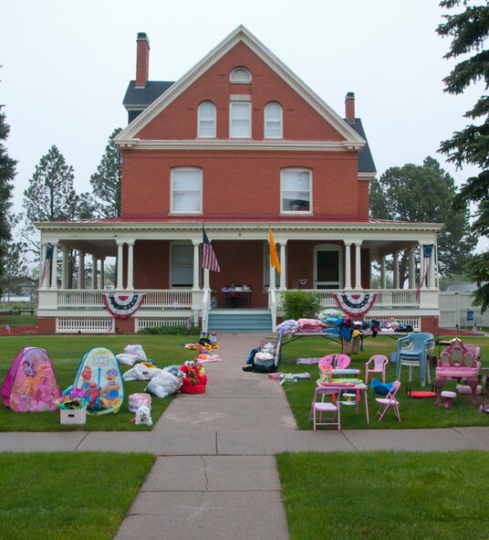 Items for sale sit outside the Farfour family's historic brick home on F.E. Warren Air Force Base, Wyo., during the base-wide yard sale June 7, 2014. Alison and Ava Farfour, daughters of Col. George Farfour, Task Force 214 director, set up the display. (U.S. Air Force photo by Airman 1st Class Jason Wiese)