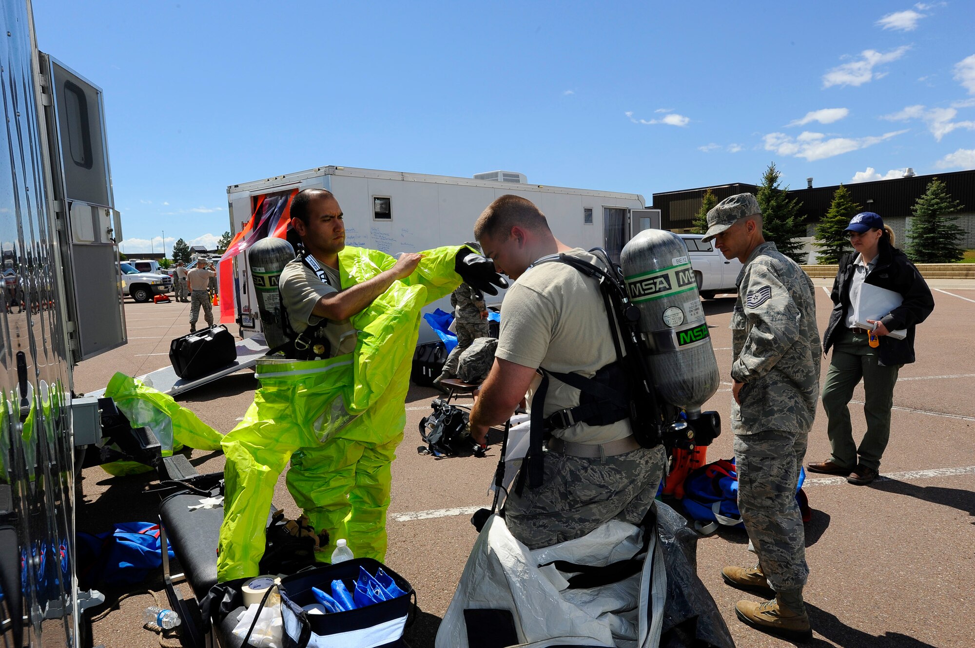 Staff Sgt. Irak Garcia-Real, 341st Medical Operations Squadron bio-environmental technician (Left), and Staff Sgt. Brock Evans, 341st Civil Engineer Squadron emergency management technician (center), prepare to enter a simulated danger zone during an exercise at Malmstrom’s old Base Exchange on June 4. Before entering the building, Garcia-Real and Evans don “level A” hazmat suits, which provide the highest level of protection from radiological and chemical hazards. (U.S. Air Force photo/Airman 1st Class Collin Schmidt)