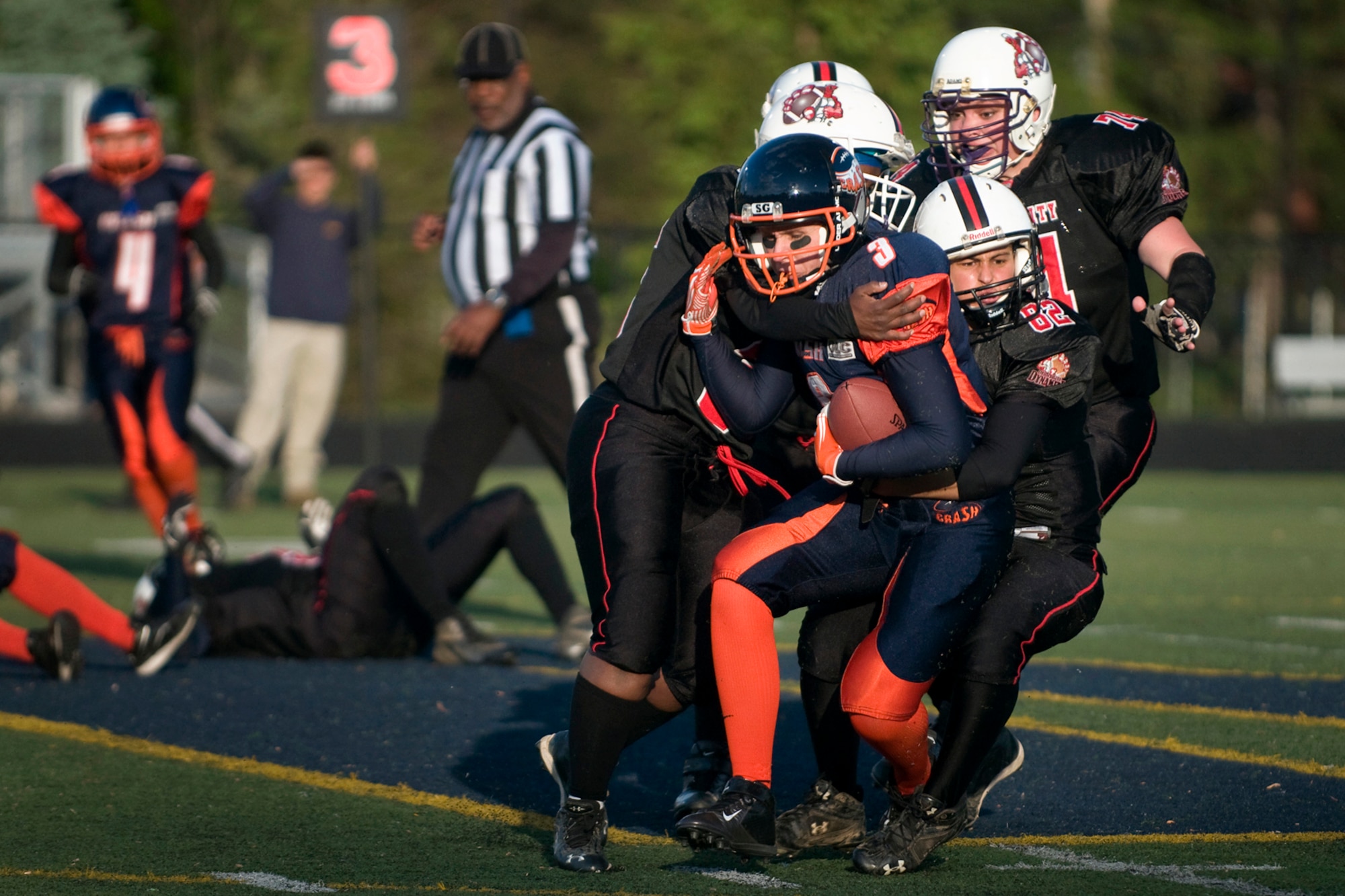 Leslie Nance, Indy Crash tight end, is tackled by four Derby City players during a football game in Indianapolis May 17, 2014. Nance is also a 445th Aeromedical Staging Squadron first sergeant at Wright-Patterson Air Force Base, Ohio, and a civilian 434th Force Support Squadron human resources specialist at Grissom Air Reserve Base, Ind. (U.S. Air Force photo/Tech. Sgt. Mark R. W. Orders-Woempner)
