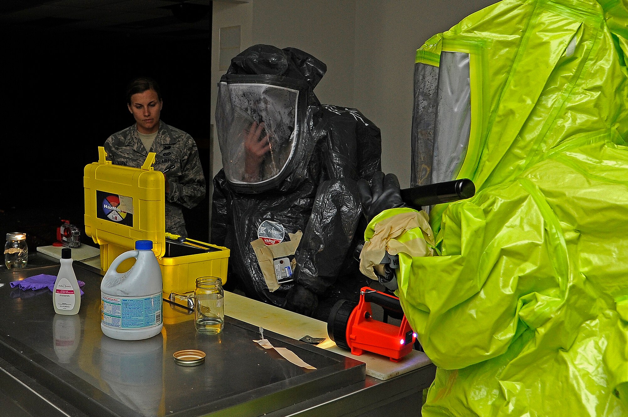 Joint emergency management and bio-environmental teams identify simulated unknown chemical hazards during a Chemical, Biological, Radiological, Nuclear and Explosive exercise at the old Base Exchange on June 4. Emergency personnel must treat hazard areas like crime scenes, to not only contain a possible threat, but collect evidence for further examination and courtroom purposes. (U.S. Air Force photo/Airman 1st Class Collin Schmidt) 
