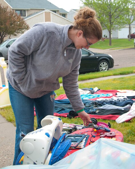 Jen Doyle-Smith, wife of Tech. Sgt. Everett Smith, 30th Airlift Squadron loadmaster, searches through the items for sale at a Carlin Heights residence during the F.E. Warren Air Force Base Yard Sale June 7, 2014. (U.S. Air Force photo by Airman 1st Class Jason Wiese)