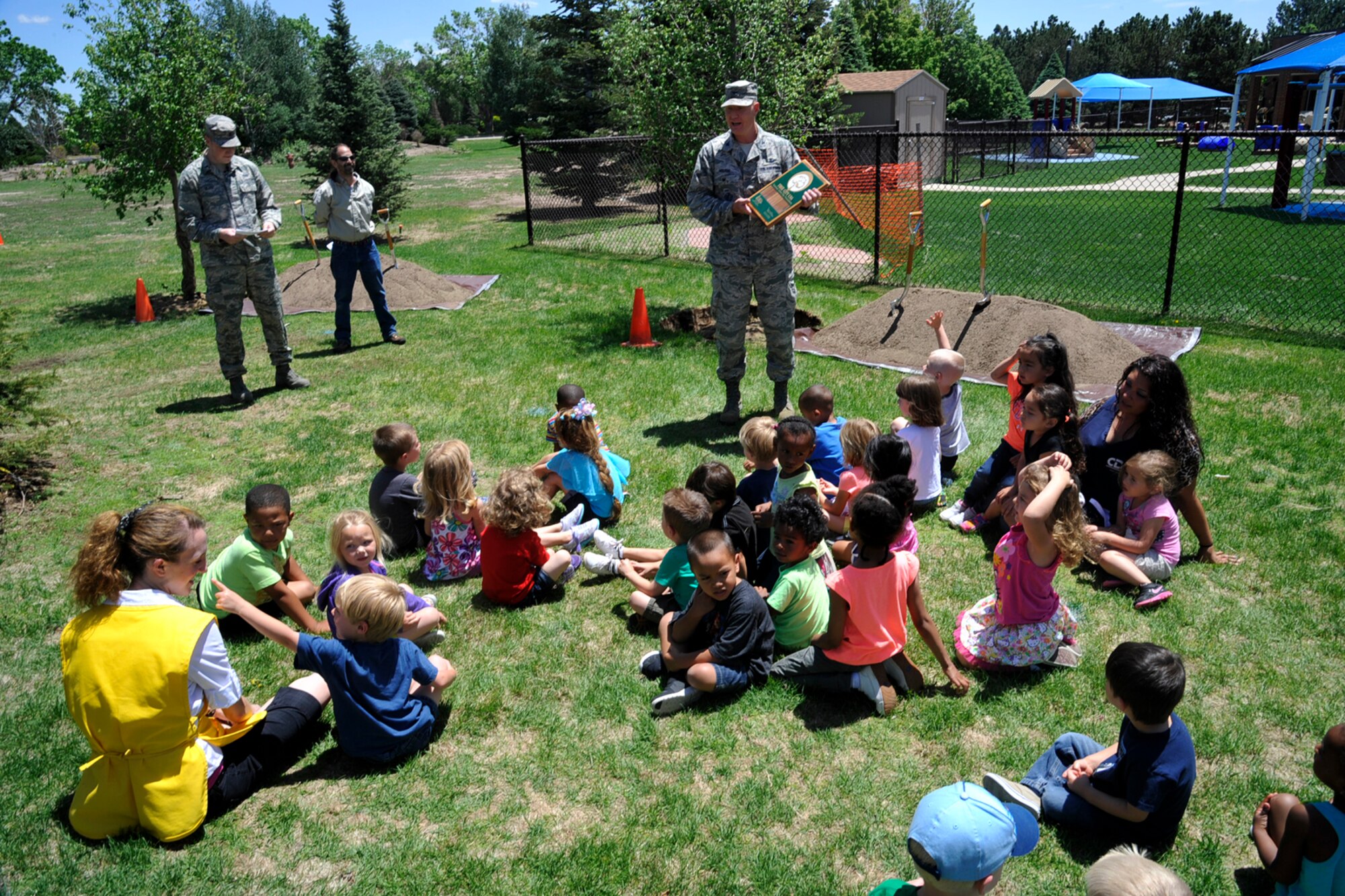 PETERSON AIR FORCE BASE, Colo. – Col. Michael Hough, 21st Space Wing vice commander, shows the Tree City USA award to children from the Peterson Child Development Center June 4. This marks the 20th year in a row that Peterson has received the Tree City award. The award, given by the Arbor Day Foundation, recognizes excellence in urban forestry management. (U.S. Air Force photo/Robb Lingley)