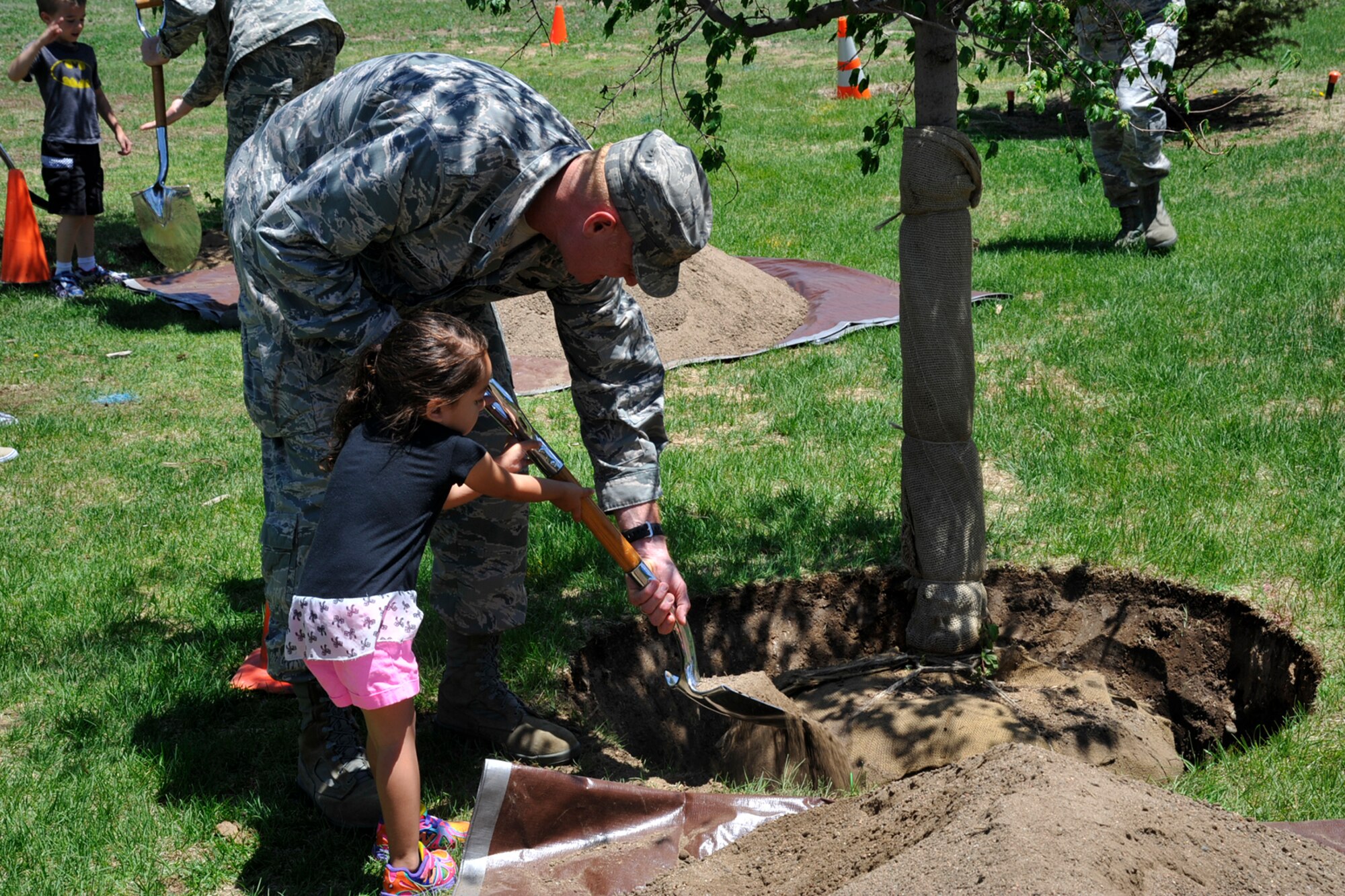 PETERSON AIR FORCE BASE, Colo. – Col. Michael Hough, 21st Space Wing vice commander, and Amaria Howell, a child at the Peterson Child Development Center, plant a tree June 4 at the CDC. Peterson AFB was presented the Tree City USA award, the 20th year in a row the base has received the honor. The award, given by the Arbor Day Foundation, recognizes excellence in urban forestry management. (U.S. Air Force photo/Robb Lingley)