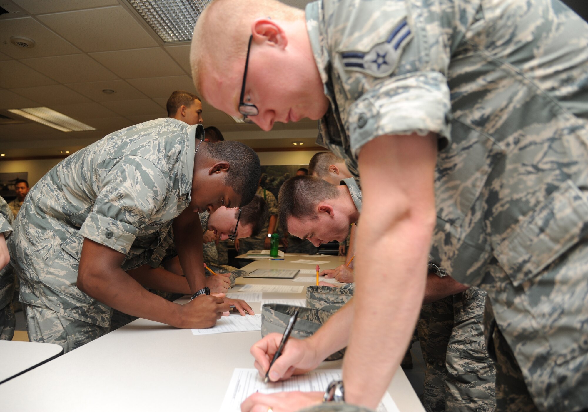 Airmen in the 335th Training Squadron complete hurricane shelter in-processing forms during a hurricane exercise June 6, 2014, at Allee Hall, Keesler Air Force Base, Miss.  The purpose of the exercise was to prepare Keesler for the current hurricane season.  (U.S. Air Force photo by Kemberly Groue)