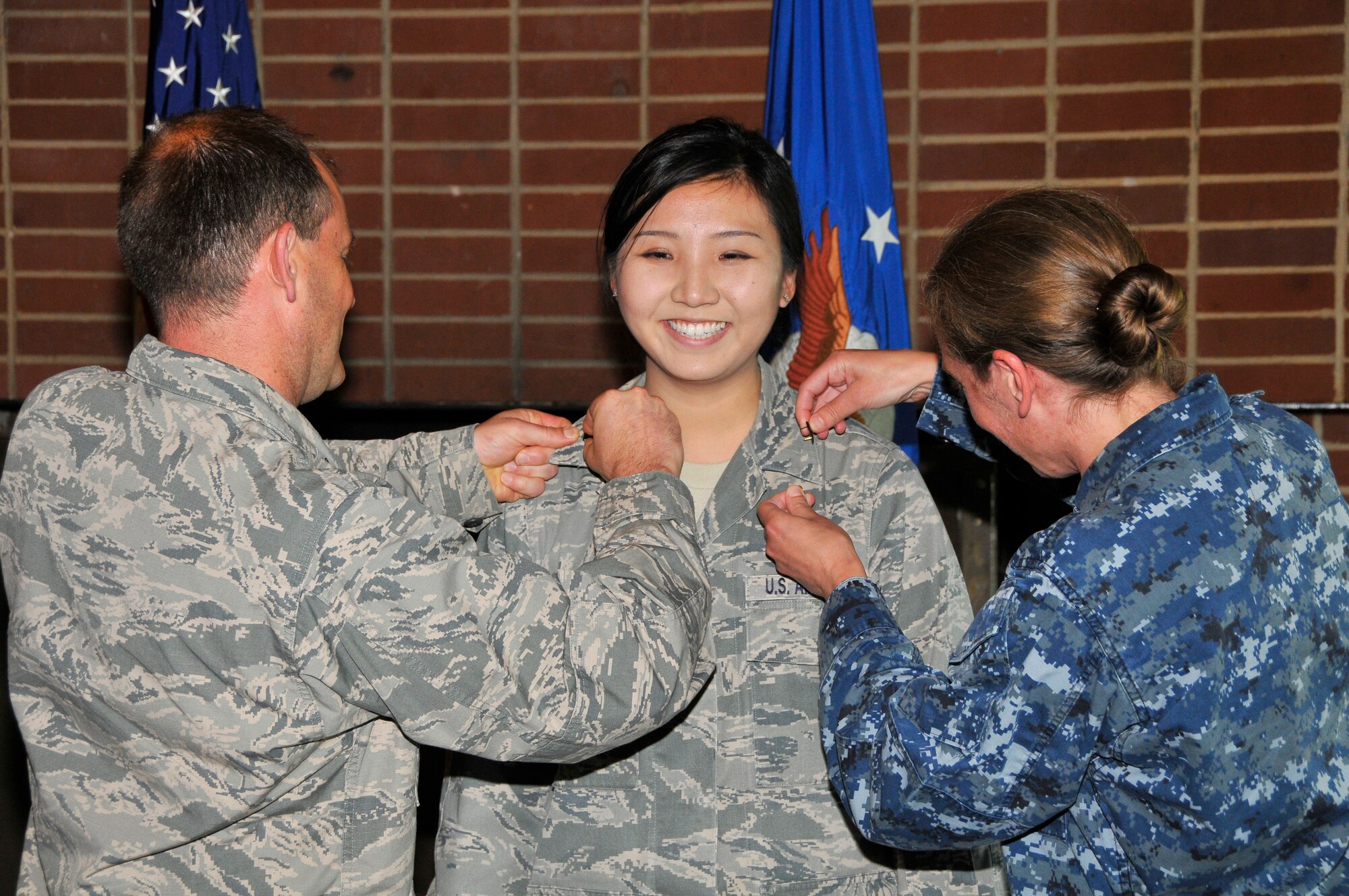 First Lt. Julie Sung (center) is pinned by U.S. Air Force Lt. Col. Jay Orson (left) and U.S. Navy Lt. Cmdr. Jessica Herman during a recent promotion ceremony where she was promoted to first lieutenant in the U.S. Air Force. (Photo by Jacqueline Cowan)