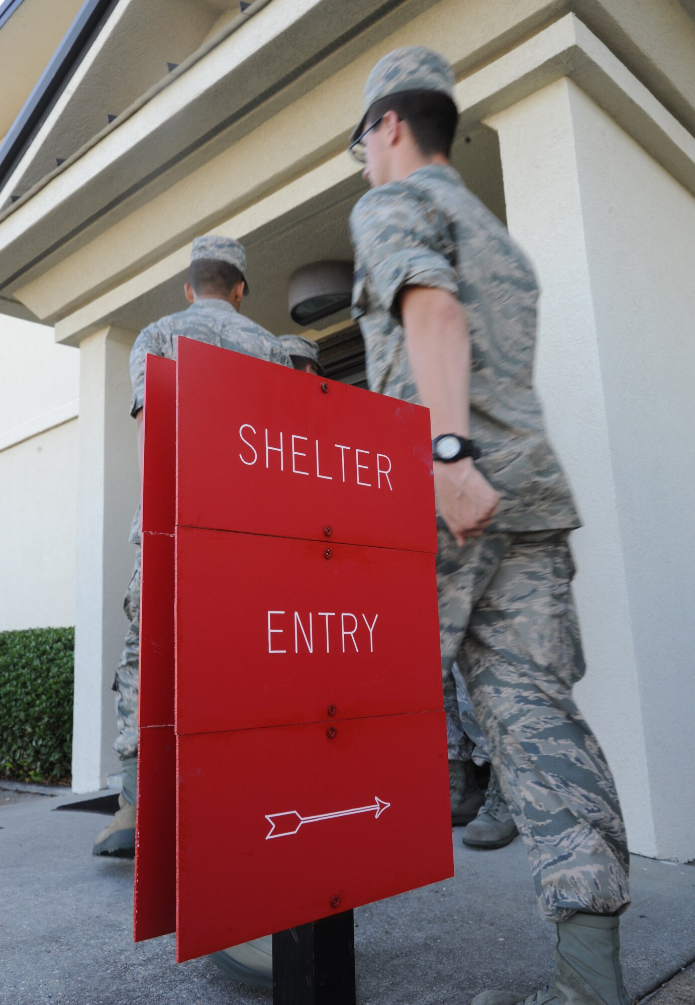 Airmen enter Allee Hall for sheltering during a hurricane exercise June 6, 2014, at Keesler Air Force Base, Miss.  The purpose of the exercise was to prepare Keesler for the current hurricane season.  (U.S. Air Force photo by Kemberly Groue)