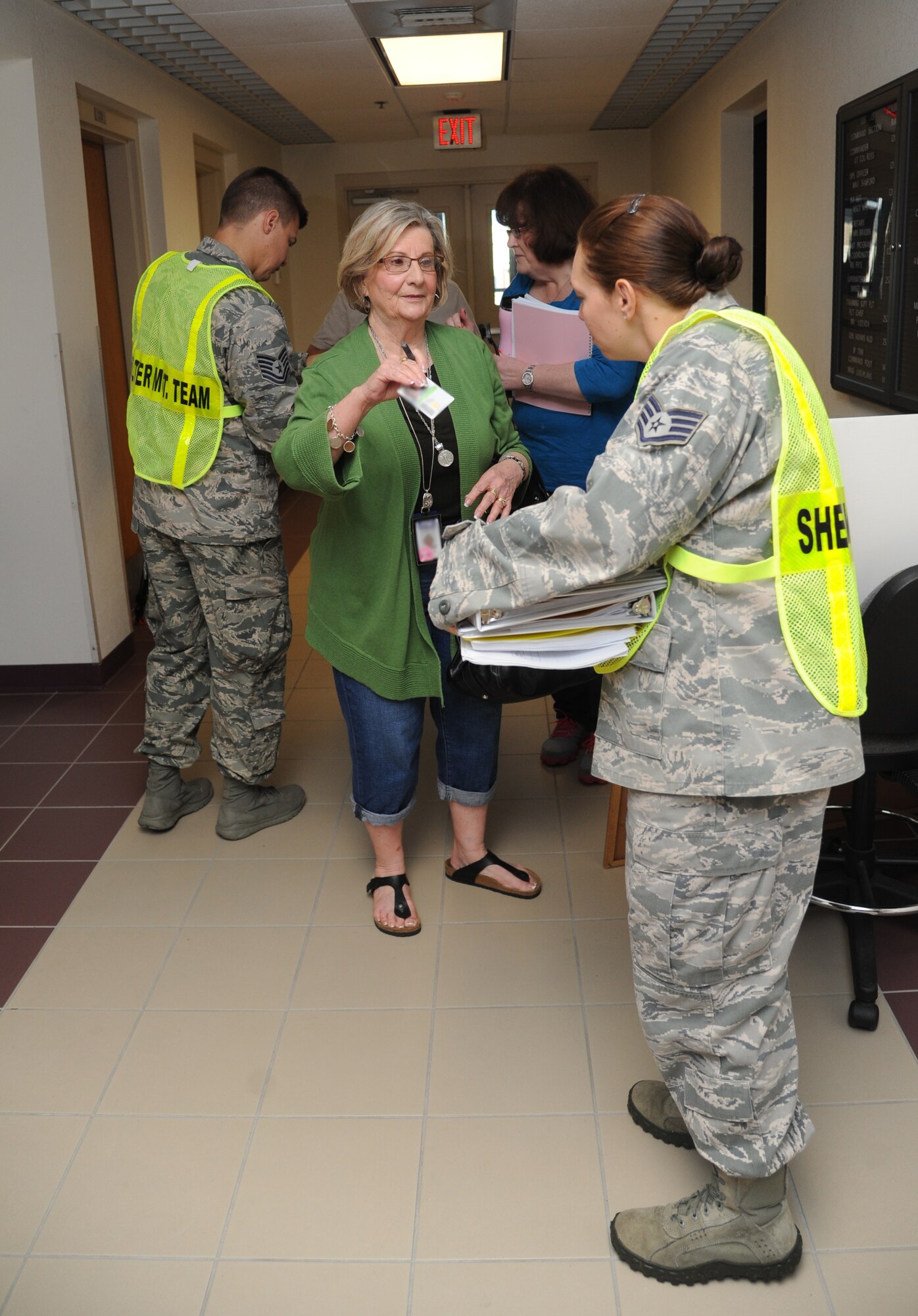 Staff Sgt. Stephanie Meyers, 335th Training Squadron and shelter management team member, checks the identification of Rena McGraw, Base Operations Support contractors, during a hurricane exercise June 6, 2014, at Wolfe Hall, Keesler Air Force Base, Miss.  The purpose of the exercise was to prepare Keesler for the current hurricane season.  (U.S. Air Force photo by Kemberly Groue)