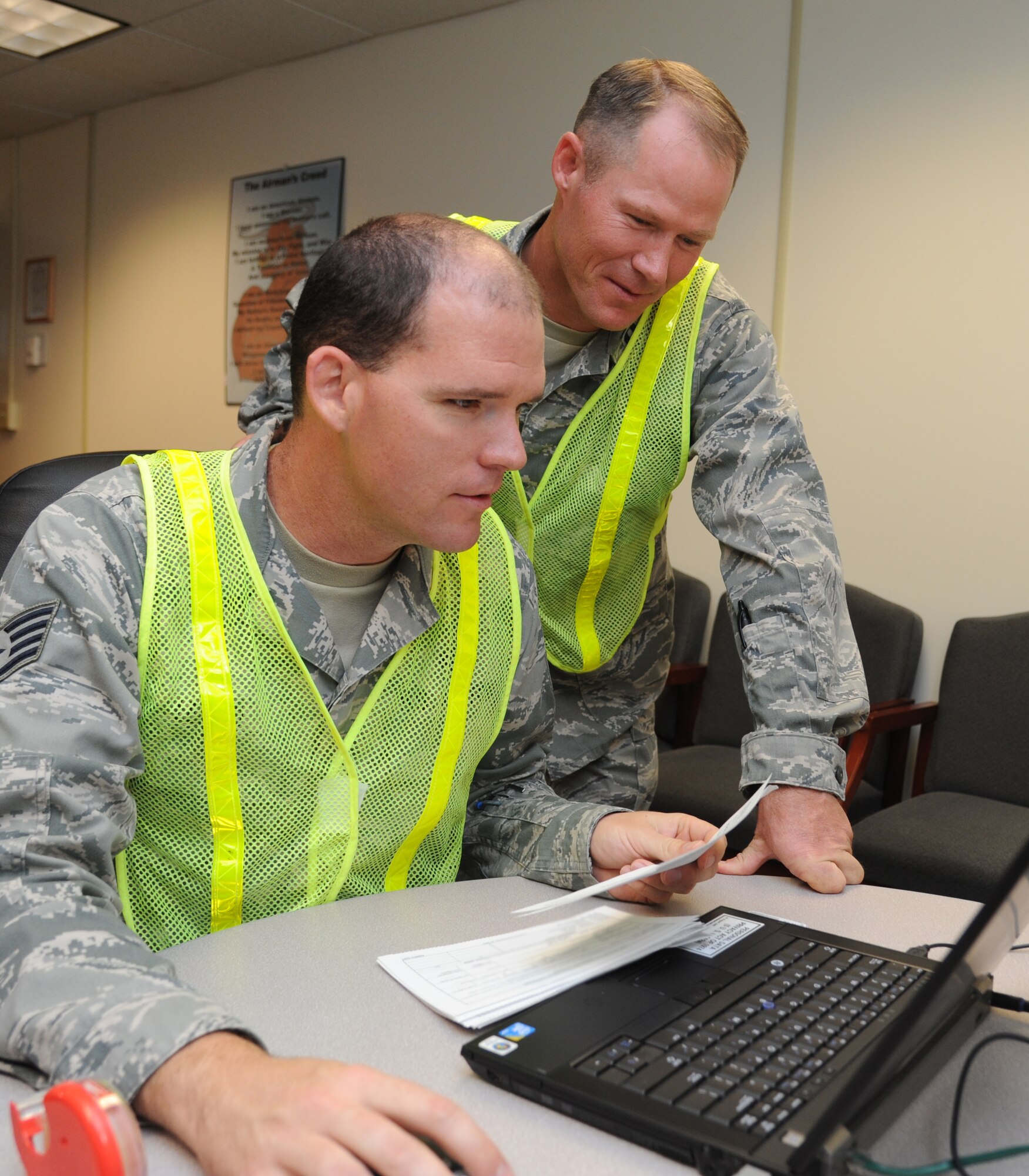 Staff Sgt. Garrett Lethco and Capt. Joshua Tate, 335th Training Squadron, and shelter management team members, input completed hurricane shelter in-processing form information into the data system during a hurricane exercise June 6, 2014, at Wolfe Hall, Keesler Air Force Base, Miss.  The purpose of the exercise was to prepare Keesler for the current hurricane season.  (U.S. Air Force photo by Kemberly Groue)
