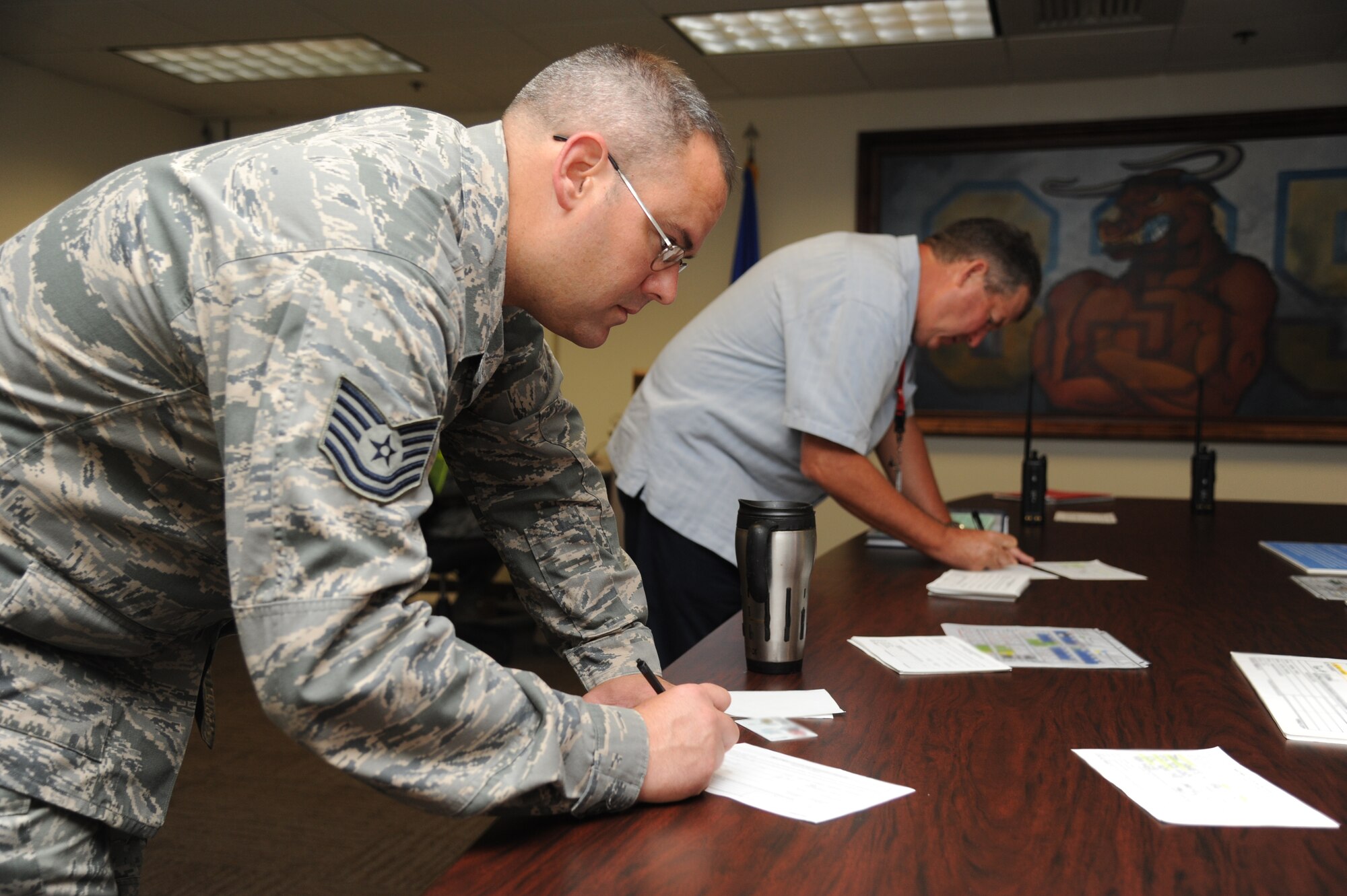 Tech. Sgt. Jon Vieira, 81st Logistics Readiness Squadron, and Mark Malone, 81st Mission Support Group, complete hurricane shelter in-processing forms during a hurricane exercise June 6, 2014, at Wolfe Hall, Keesler Air Force Base, Miss.  The purpose of the exercise was to prepare Keesler for the current hurricane season.  (U.S. Air Force photo by Kemberly Groue)