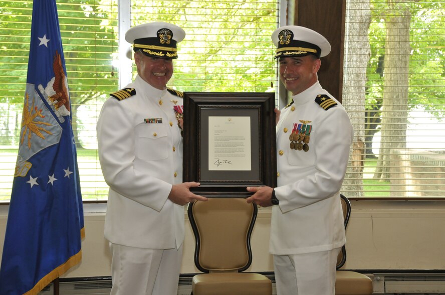 Cmdr. Brian Allen (right), with the U.S. Navy and the Arnold Engineering Development Complex (AEDC) Test Support Division director of operations, receives a letter for best wishes from former President George W. Bush during his retirement ceremony presented by Capt. Sam “Pappy” Paparo, Allen’s close personal friend and who served as the retiring officer. (Photo by Rick Goodfriend)