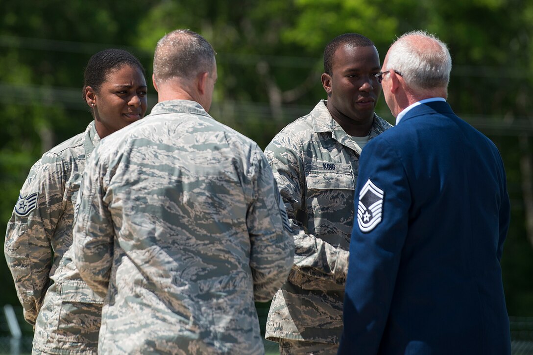 U.S. Air Force Staff Sgt. Tony King is congratulated by retiring Senior Master Sgt. Jack Bartleson during an AMMO Pinning ceremony on June 7, 2014, Barksdale Air Force Base, La. Bartleson presented five deserving Airmen with the pin during his retirement ceremony. (U.S. Air Force photo by Master Sgt. Greg Steele/Released)