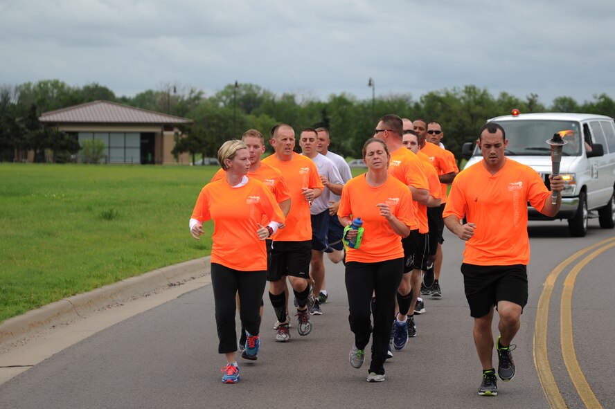 Airmen from the 22nd Security Forces Squadron participate in a the torch run for the Special Olympics, June 6, 2014, McConnell Air Force Base, Kan. Every two years, law enforcement officers from around the world come together to participate in the largest fundraising opportunity for the Special Olympics World Summer and Winter Games. (U.S. Air Force photo/Airman 1st Class Aaron-Forrest Wainwright)