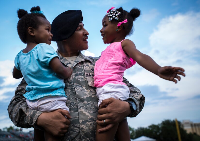 Airman 1st Class Kyren Gantt, 628th Security Forces Squadron patrolman, is reunited with his daughters, Kylie and Ma’kya, June 6, 2014, at Joseph P. Riley Park in Charleston, S.C. Gantt had just returned from an eight-month deployment to Osan Air Base, Republic of Korea. (U.S. Air Force photo/ Airman 1st Class Clayton Cupit)