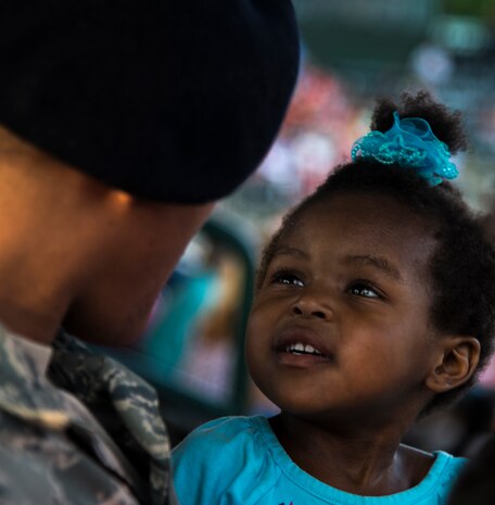 Airman 1st Class Kyren Gantt, 628th Security Forces Squadron patrolman, is reunited with his daughter, Kylie, June 6, 2014, at Joseph P. Riley Park in Charleston, S.C. Gantt just returned from an eight-month deployment to Osan Air Base, Republic of Korea. (U.S. Air Force photo/ Airman 1st Class Clayton Cupit)