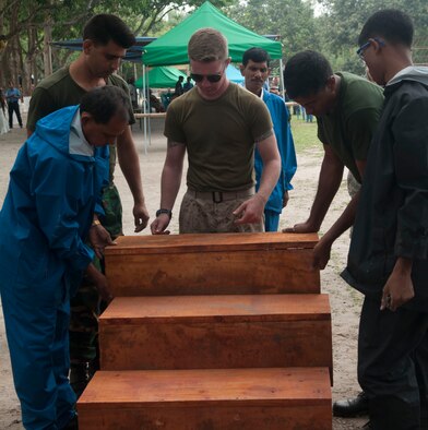 U.S. Marine Lance Cpl. Devon Doane helps build therapy stairs along with Bangladesh Army engineers and contractors on May 30, 2014 near Rangpur, Bangladesh. The stairs were donated to the Proyash School Rangpur Cantonment for use in occupational therapy for special needs children as part of Operation Pacific Angel. (U.S. Air Force Photo/Capt. Cait Suttie)