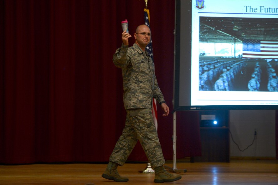 U.S. Air Force Chief Master Sgt. Charles Mills, 20th Fighter Wing command chief, displays a sippy cup during an enlisted all-call at Shaw Air Force Base, S.C., June 9, 2014. Telling the story of why he picked up the sippy cup from the ground after seeing it for three weeks, Mills explained to the Airmen of the 20th FW the importance of being situationally aware of everything around. Mills also spoke about his personal and professional background and the importance of each rank in the enlisted structure. (U.S. Air Force photo by Airman 1st Class Jensen Stidham/Released)