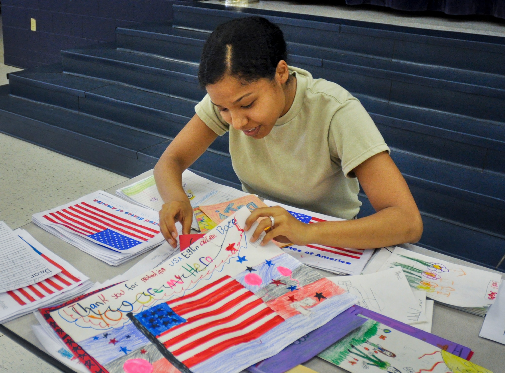 2nd Lt. Tina McAfee, from the 86th Fighter Weapons Squadron, folds letters at the Eglin Elementary School cafeteria during the troop care drive June 6.  The Company Grade Officer’s Council collected 216 handwritten letters and drawings from Destin Elementary School students.  These letters and drawings were included in the care packages along with sundry comfort items.  The items were donated by the CGOC, who also hosted the event.  Volunteers packed a total of 108 care packages for Eglin’s deployed. (U.S. Air Force photo/Ilka Cole)