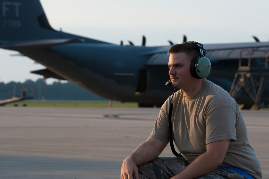 U.S. Air Force Senior Airman Robert Brock, 71st Aircraft Maintenance Unit crew chief, crouches during a pre flight operational check at Moody Air Force Base, Ga., June 5, 2014. Each flight takes approximately eight hours to prepare, including various maintenance, fueling and operations checks. (U.S. Air Force photo by Airman 1st Class Ryan Callaghan/Released)