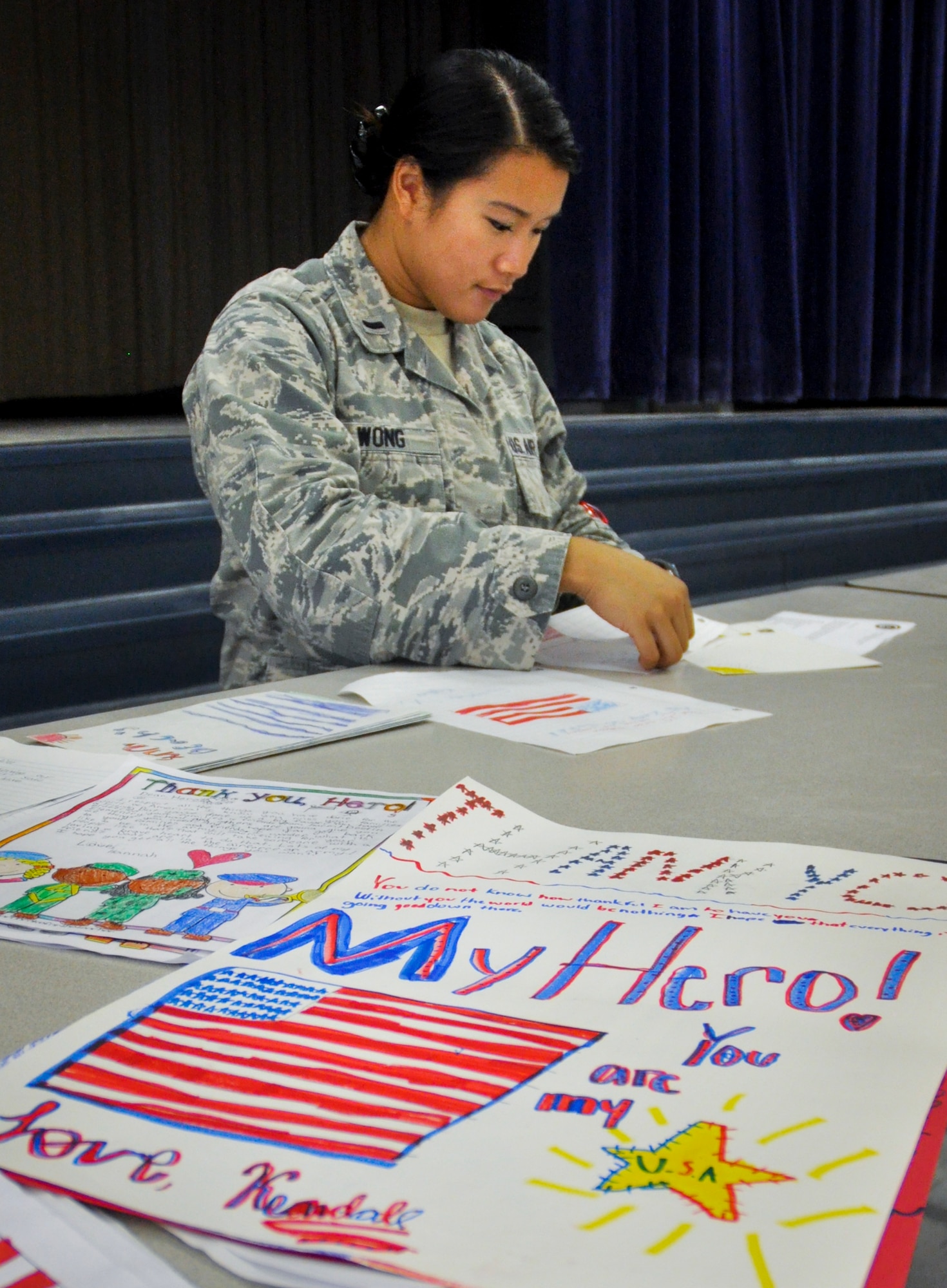 1st Lt. Lisa Wong, of the Air Force Life Cycle Management Center folds letters at the Eglin Elementary School cafeteria during the troop care drive June 6.  The Company Grade Officer’s Council collected 216 handwritten letters and drawings from Destin Elementary School students.  These letters and drawings were included in the care packages along with sundry comfort items.  The items were donated by the CGOC, who also hosted the event.  Volunteers packed a total of 108 care packages for Eglin’s deployed. (U.S. Air Force photo/Ilka Cole)