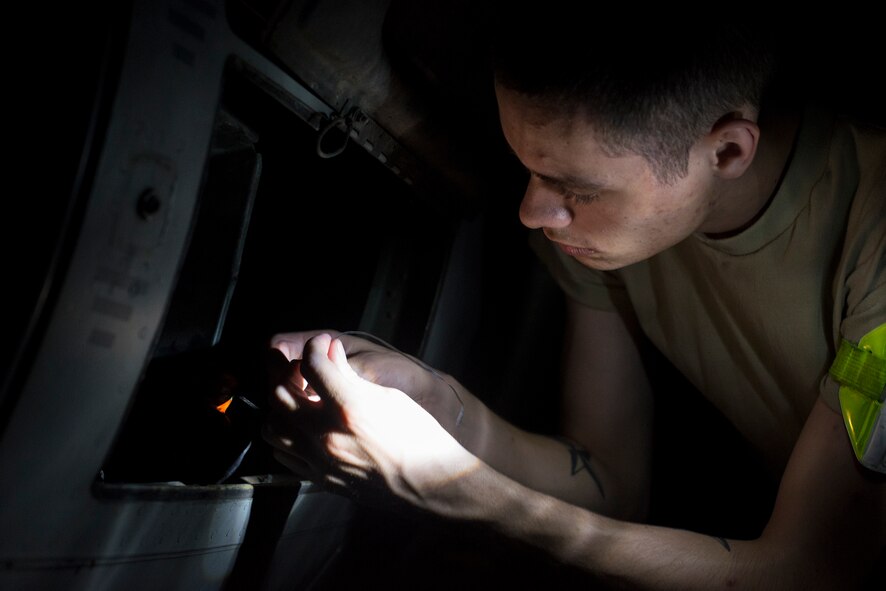 U.S. Air Force Airman 1st Class Nolan Miller, 71st Aircraft Maintenance Unit communication, navigation and mission systems apprentice, bundles electrical connections on an HC-130P Combat King at Moody Air Force Base, Ga., June 4, 2014. Before an aircraft is retired, it is stripped down to only the mission-essential components. The removed systems are then used as replacement parts on remaining aircraft. (U.S. Air Force photo by Airman 1st Class Ryan Callaghan/Released)