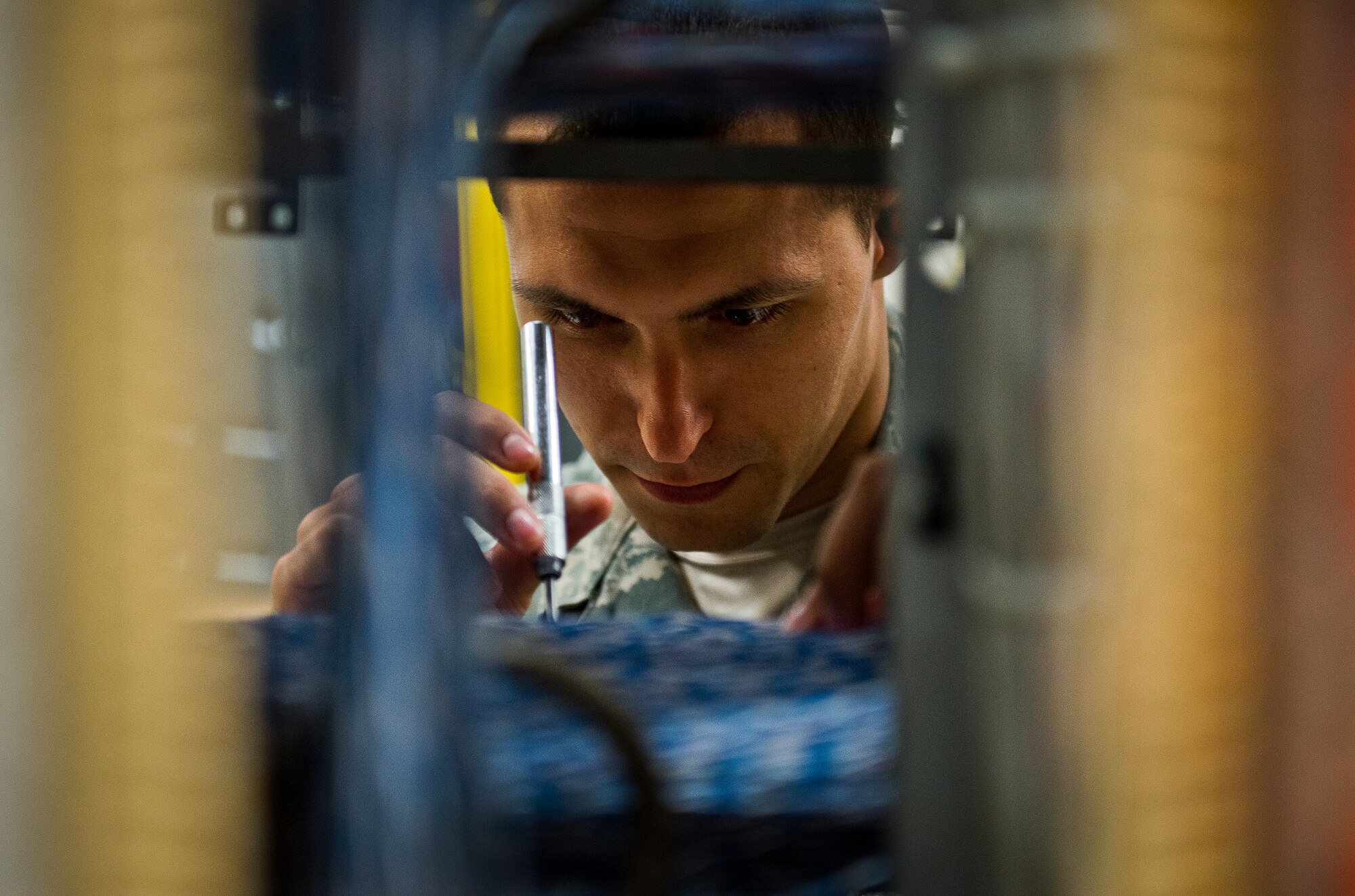 Senior Airman Ryan Thomas, of the 96th Communications Squadron’s voice network systems, completes a wire cross connection of a single phone line located on the main wire distribution frame supporting all copper wire connections on base June 6 at Eglin Air Force Base, Fla.  The 22 Airmen and civilians within voice network systems branch are responsible for the maintenance and preservation of more than 18,000 bases phone lines.  Their contributions combined with the other branches and flights led to the 96th CS earning the 2013 Maj. Gen. Harold McClelland best large communications work center award for Air Force Materiel Command. (U.S. Air Force photo/Samuel King Jr.)