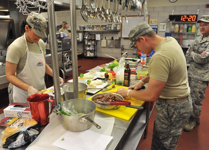 Staff Sgt. Hangie De Los Santos, 341st Force Support Squadron remote nuclear facility chef (left) and Staff Sgt. Eldoris Gardner, 341st FSS food service craftsman, put the final touches on their entrées as time runs out before Warrior Chef judging begins June 3. (U.S. Air Force photo / John Turner)