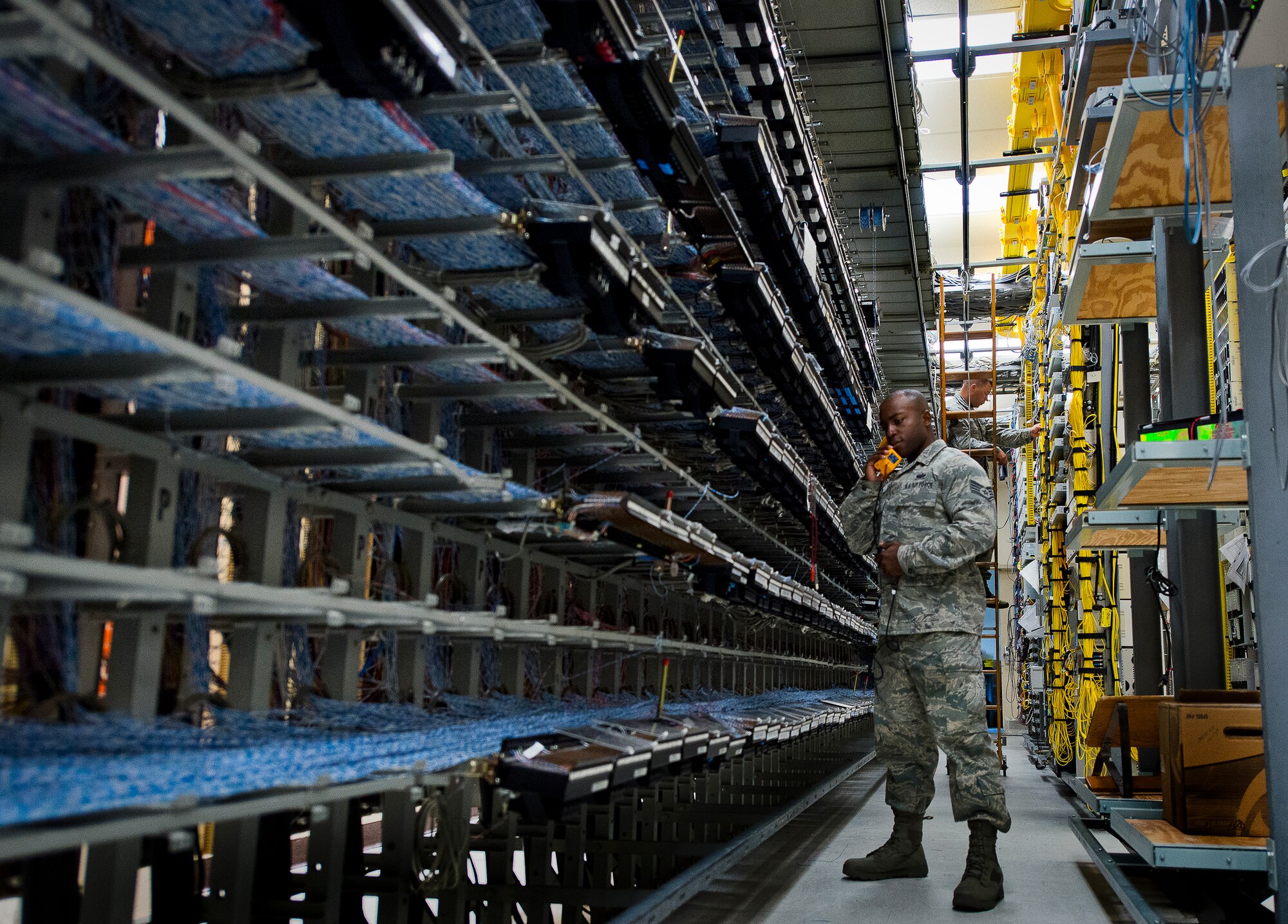 Staff Sgt. Patric Thompson, of the 96th Communications Squadron’s voice network systems, troubleshoots a base telephone line while Tech. Sgt. Greg Gustafson, examines a bundle of cabling lines June 6 at Eglin Air Force Base, Fla.  The 22 Airmen and civilians within voice network systems branch are responsible for the maintenance and preservation of more than 18,000 bases phone lines.  Their contributions combined with the other branches and flights led to the 96th CS earning the 2013 Maj. Gen. Harold McClelland best large communications work center award for Air Force Materiel Command. (U.S. Air Force photo/Samuel King Jr.)