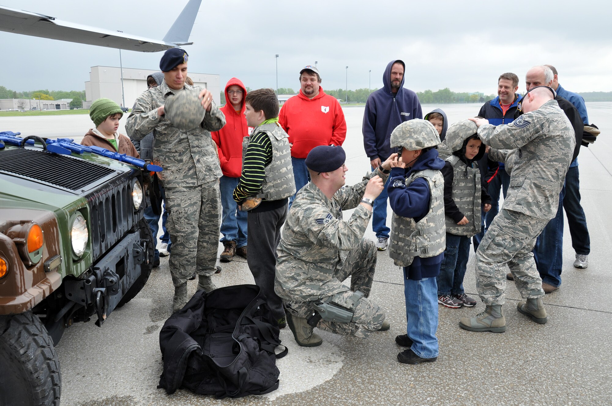 WRIGHT-PATTERSON AIR FORCE BASE, Ohio - Staff Sgt. Gustavo Medina, Senior Airman Mark Murphy and Tech. Sgt. Steve Wright, 445th Security Forces Squadron, help Scouts put on security forces gear as they prepare to participate in a scenario during Scouts Day May 17. More than 50 Scouts and their adult leaders from the local area enjoyed a morning of activities on the 445th fligthline. Activities included a tour of a C-17 Globemaster III, demonstrations by security forces and the 445th Aeromedical Evacuation Squadron, and tour of a base fire truck. (U.S. Air Force photo/Lt. Col. Denise Kerr)