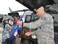 WRIGHT-PATTERSON AIR FORCE BASE, Ohio - Staff Sgt. Gustavo Medina, 445th Security Forces Squadron, hands a toy gun to a Scout as they prepare to participate in a security forces scenario during Scouts Day May 17. More than 50 Scouts and their adult leaders from the local area enjoyed a morning of activities on the 445th fligthline. Activities included a tour of a C-17 Globemaster III, demonstrations by security forces and the 445th Aeromedical Evacuation Squadron, and tour of a base fire truck. (U.S. Air Force photo/Lt. Col. Denise Kerr)