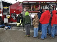 WRIGHT-PATTERSON AIR FORCE BASE, Ohio - Tech. Sgt. Dale Quigley, 445th Civil Engineer Squadron firefighter, talks to Scouts attending the May 17 445th Airlift Wing Scouts Day about his firefighter gear he wears when he responds to an emergency. The 445th Airlift Wing hosted its annual Scouts Day May 17. More than 50 Boy and Cub Scouts from around the state enjoyed a morning of activities on the 445th flightline, to include a tour of a C-17 Globemaster III, base fire truck, demonstrations by 445th Security Forces Squadron and the 445th Aeromedical Evacuation Squadron. (U.S. Air Force photo/Lt. Col. Denise Kerr)