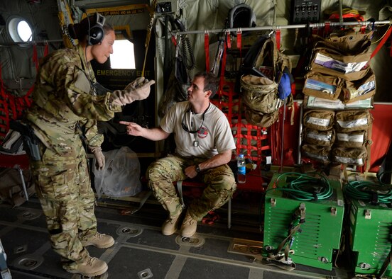 (From left) U.S. Air Force Capts. Cherry Fowler and Chad Moore, 455th Expeditionary Aeromedical Evacuation Squadron discuss flight details during a aeromedical evacuation mission at Kandahar Airfield, Afghanistan May 29, 2014. The Aeromedical Evacuation squadron transports and treats ill and injured personnel throughout Afghanistan. The unit uses fixed-wing aircraft such as the C-130J Super Hercules, which allows larger patient loads, long-distance transportation and a greater ability to care for injured members. Fowler is a flight nurse delpoyed from Air Force Reserve Command's 302nd Airlift Wing, Peterson Air Force Base, Colo. and a native Watertown S.D. Moore is a Critical Care Air Transport Team nurse deployed from Wright-Patterson Air Force Base, Ohio. and a native of New Brockton, Ala. (U.S. Air Force photo by Staff Sgt. Evelyn Chavez/Released)