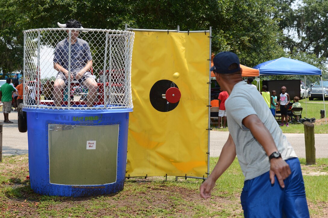 Master Sgt. Kenneth Holmes, 41st Aerial Port Squadron air transportation aerial porter, tosses a ball in an attempt to dump Capt. Daniel Harrison, 403rd Force Support Squadron operations officer, into the dunking booth during the 403rd Wing Family Day event at Keesler Air Force Base, Mississippi, June 7, 2014. Col. Frank L. Amodeo, 403rd Wing commander, said the event served as an opportunity for wing and family members to take a break, spend time together, and have some fun. (U.S. Air Force photo/Tech. Sgt. Ryan Labadens)