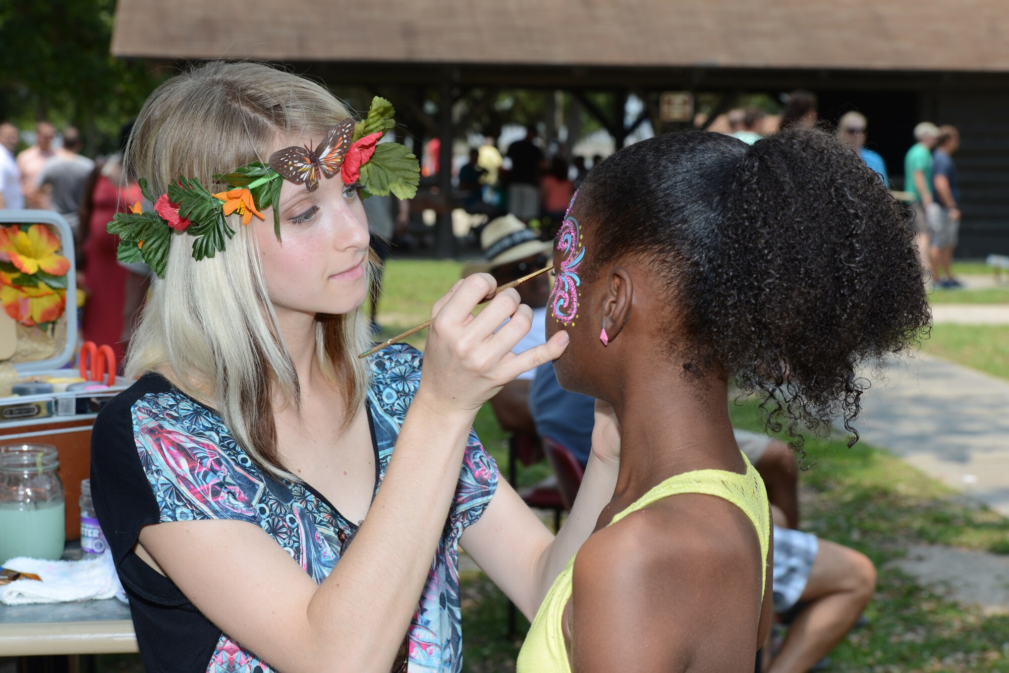 Autumn Leith paints a butterfly on the face of a 403rd Wing family member during the 403rd Wing Family Day event at Keesler Air Force Base, Mississippi, June 7, 2014. Col. Frank L. Amodeo, 403rd Wing commander, said the event served as an opportunity for wing and family members to take a break, spend time together, and have some fun. (U.S. Air Force photo/Tech. Sgt. Ryan Labadens)