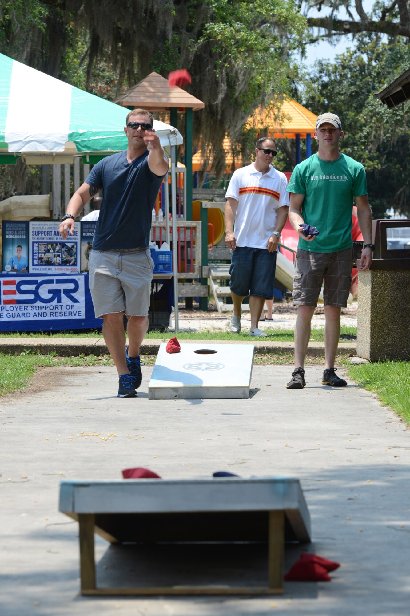 Capt. Luke Caulder (left), 53rd Weather Reconnaissance Squadron pilot, and Senior Airman Matthew Peglow, 41st Aerial Port Squadron aerial transportation journeyman, play a game of beanbag toss during the 403rd Wing Family Day event at Keesler Air Force Base, Mississippi, June 7, 2014. Col. Frank L. Amodeo, 403rd Wing commander, said the event served as an opportunity for wing and family members to take a break, spend time together, and have some fun. (U.S. Air Force photo/Tech. Sgt. Ryan Labadens)