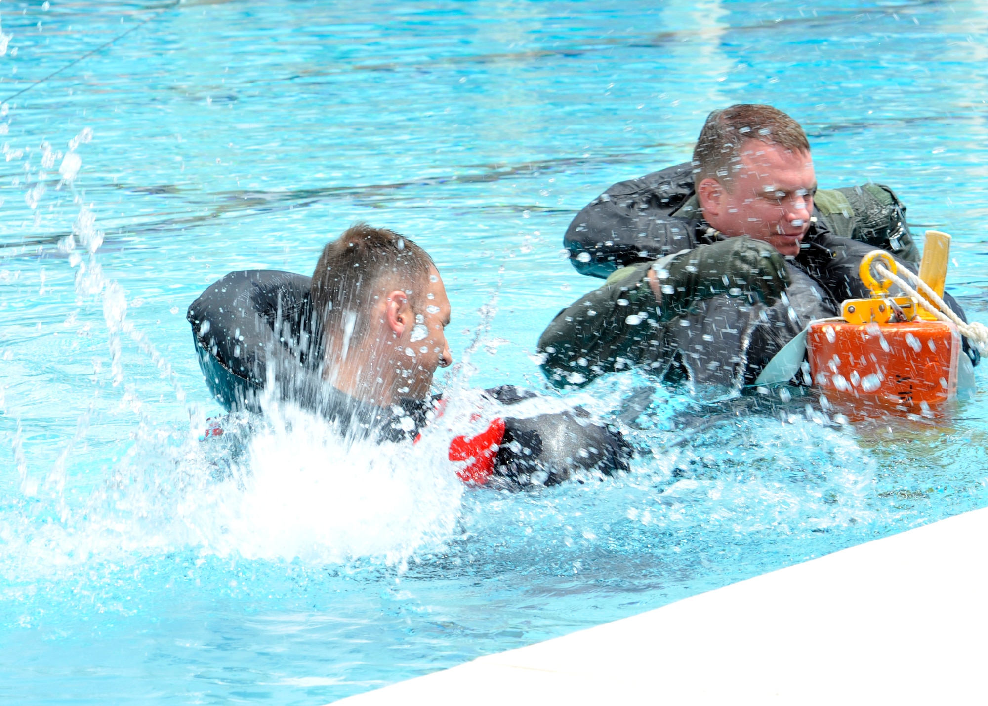 Capt. Brent Ellis, 309th FS instructor pilot, and Maj. Brendan Shannon, 309th FS director of operations, simulate a rescue. A rescue sling is donned under the arms with the arms folded in front. A thumbs-up indicates a go ahead with the lift. (U.S. Air Force photo/Senior Airman Marcy Copeland)