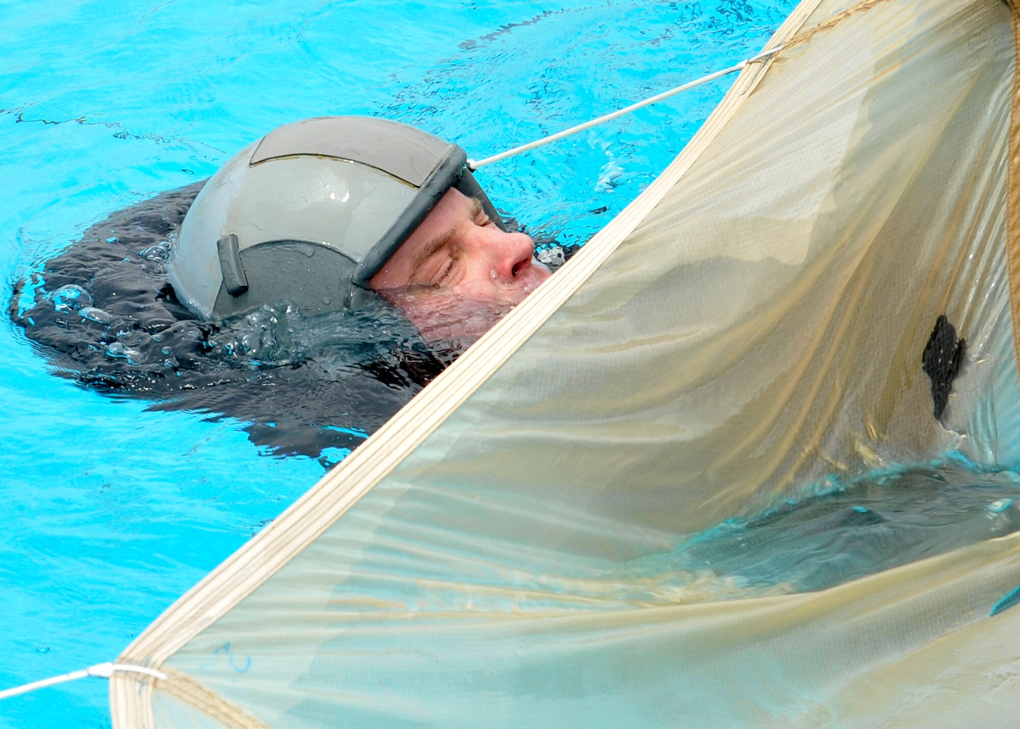Maj. Brendan Shannon, 309th Fighter Squadron director of operations, follows a parachute seam May 28 at Luke Air Force Base during annual Survival, Evasion, Resistance and Escape training. If a parachute lands on top of the pilot during a water landing, following the parachute seam will guide the pilot from beneath the chute to safety and could save his or her life. (U.S. Air Force photo/Senior Airman Marcy Copeland)