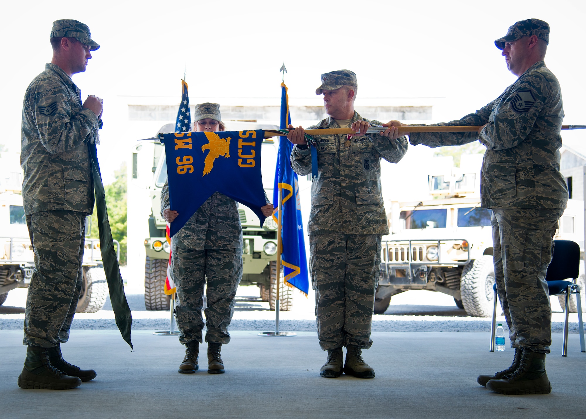 Col. Lisa Hanson, the 96th Mission Support Group commander, and Maj. James Habeck, the 96th Ground Combat Training Squadron commander, roll up the squadron’s guidon during its inactivation ceremony June 6 at Eglin Air Force Base, Fla.  The squadron will be fully deactivated by Oct. 1 and its mission of training deploying security forces Airmen will move to Fort Bliss, Texas.  (U.S. Air Force photo/Samuel King Jr.)