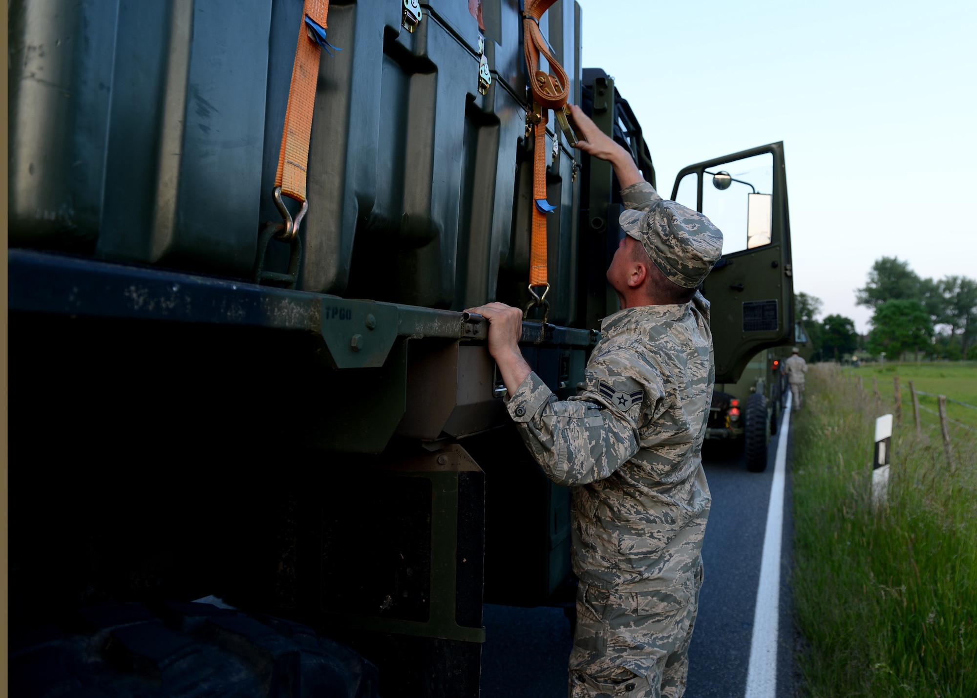 U.S. Air Force Gerremy Fearson, 606th Air Control Squadron power production apprentice, Spangdahlem Air Base, Germany, tightens cargo straps during a convoy to Poland, June 2, 2014. The convoy arrived at Powidz Air Base, Poland, to support the U.S Aviation Detachment during Exercise EAGLE TALON and Av-Det Rotation 14-3. The Av-Det was chartered to increase partnership capacity with Poland and other NATO allies through theater security cooperation events. (U.S. Air Force photo by Airman 1st Class Kyle Gese/Released)