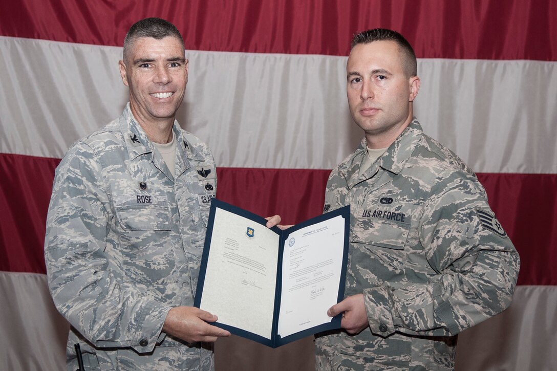 U.S. Air Force Col. Kenneth Rose, commander, 307th Maintenance Group, presents Staff Sgt. Lance Duay with Letters of Appreciation from Lt. Gen. Stephen Wilson, commander of the Air Force Global Strike Command (AFGSC), and Col. Jonathan Ellis, commander, 307th Bomb Wing, during the Maintenance Group Commander's Call, June 7, 2014, in Hoban Hall at Barksdale Air Force Base, La. Wilson commended Duay on behalf of the more than 25,000 men and women of the AFGSC for his outstanding efforts as part of the protocol support team during Admiral Haney’s recent visit. (U.S. Air Force photo by Master Sgt. Jeff Walston/Released)