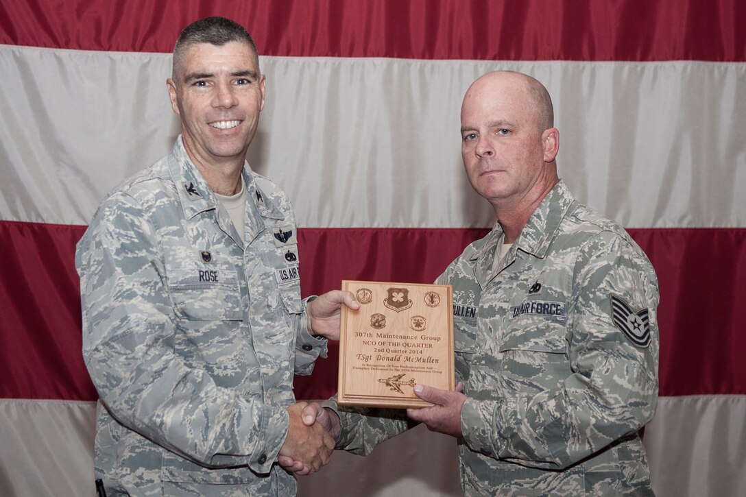 U.S. Air Force Col. Kenneth Rose, commander, 307th Maintenance Group, presents the Maintenance Group Noncommissioned Officer of the Quarter award for the period covering April through June, to Tech. Sgt. Donald McMullen 307th Maintenance Squadron, during a Maintenance Group Commander's Call, June 7, 2014, in Hoban Hall at Barksdale Air Force Base, La. McMullen was selected as the Maintenance Group’s second quarter winner for 2014. (U.S. Air Force photo by Master Sgt. Jeff Walston/Released)