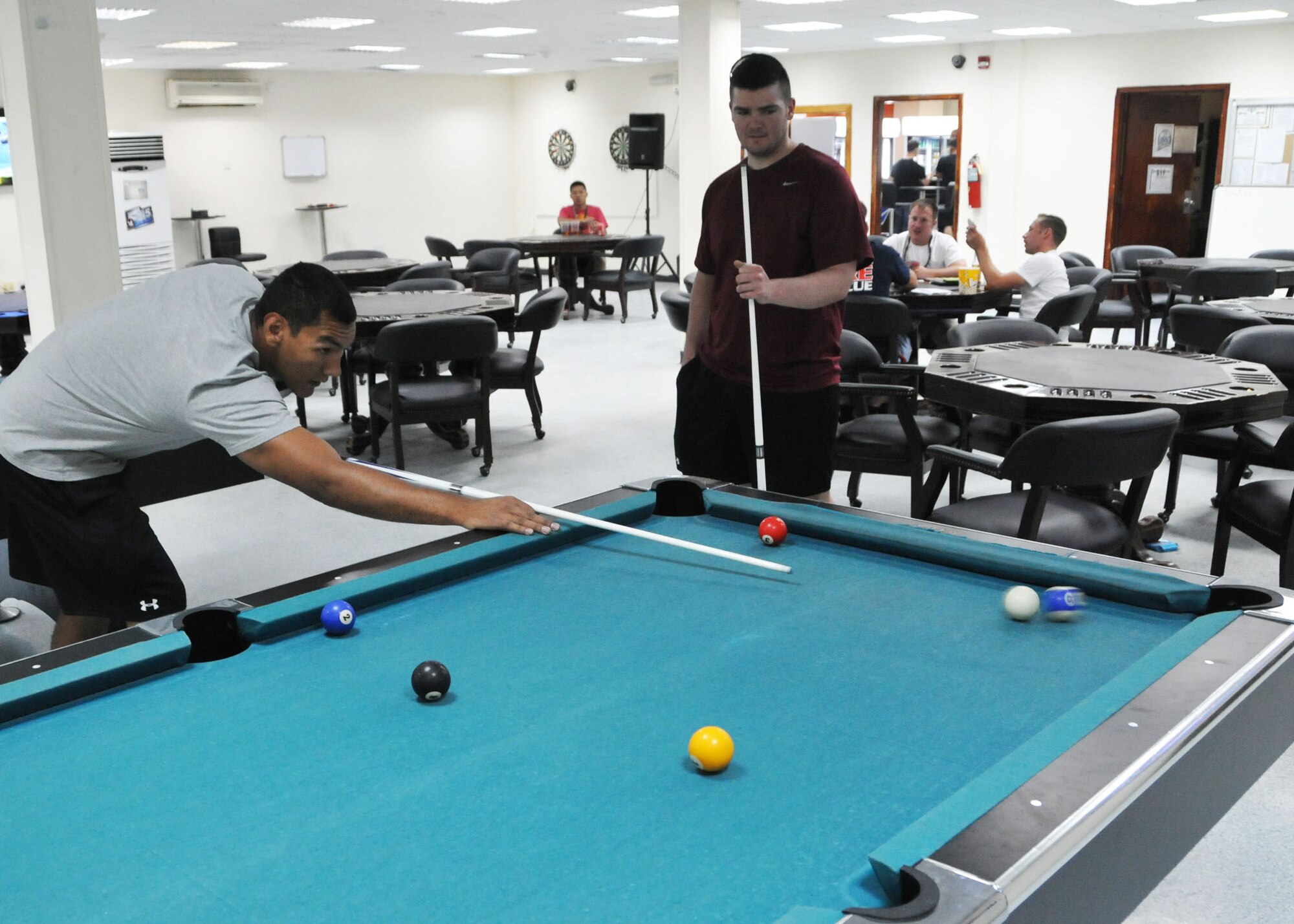 Air Force Senior Airman Troy Marquez shoots the 10 ball into the corner pocket during a game of pool with Staff Sgt. Jarriott Bennett at the 380th Air Expeditionary Wing’s community activities center at an undisclosed location of Southwest Asia June 1, 2014. (U.S. Air Force photo by Senior Master Sgt. Eric Peterson/Released)