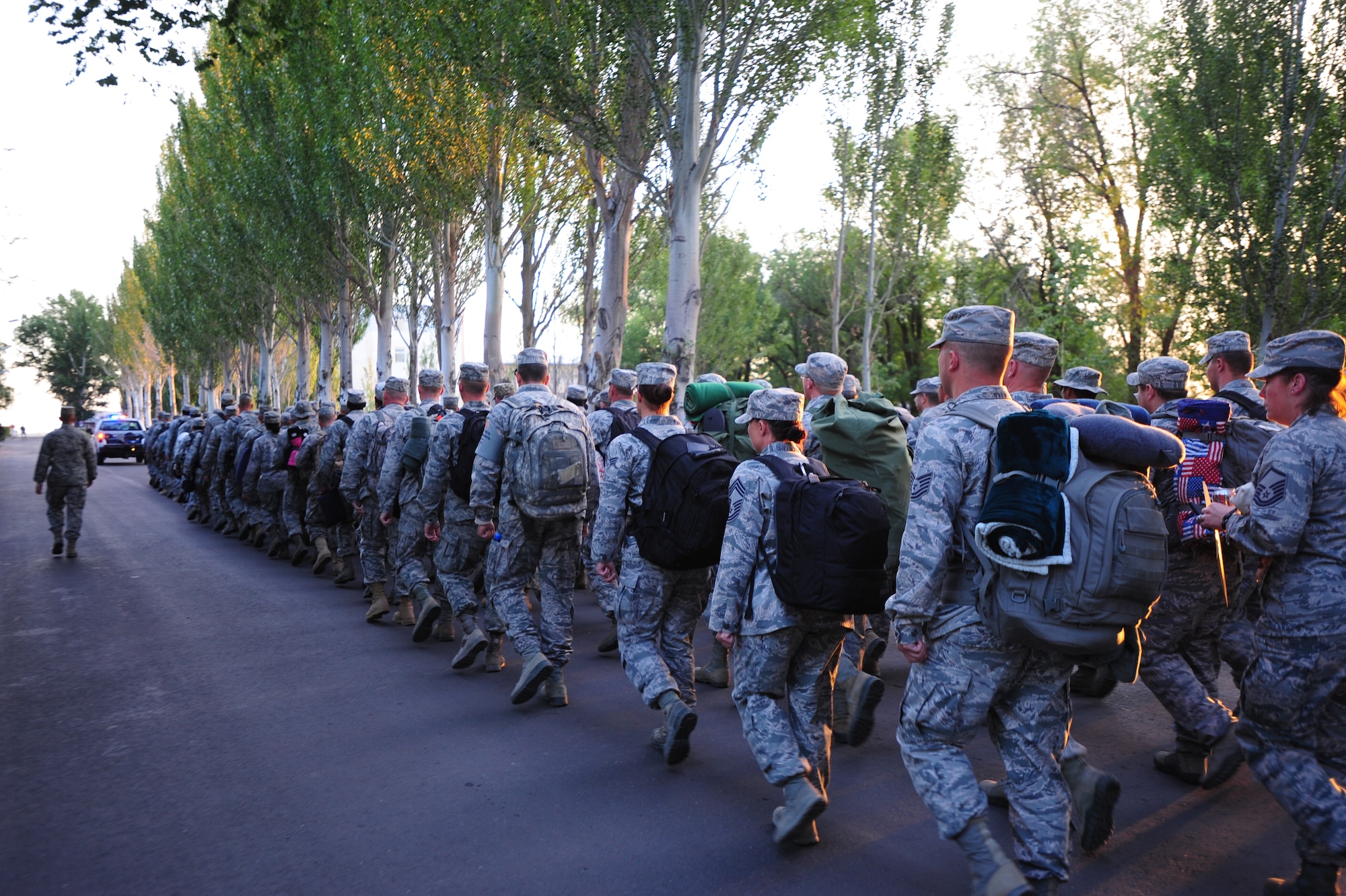 Airmen from the 376th Air Expeditionary Wing shoulder bulky carry-on luggage and keep in step as they march from the Transit Center at Manas, Kyrgyzstan  to the Manas International Airport flight line June 6, 2014.  During its 12.5-year tenure, the Transit Center supported more than 42,000 airlift missions with more than 1.4 million pounds of cargo moved. (U.S. Air Force photo/Lt. Col. Max Despain)