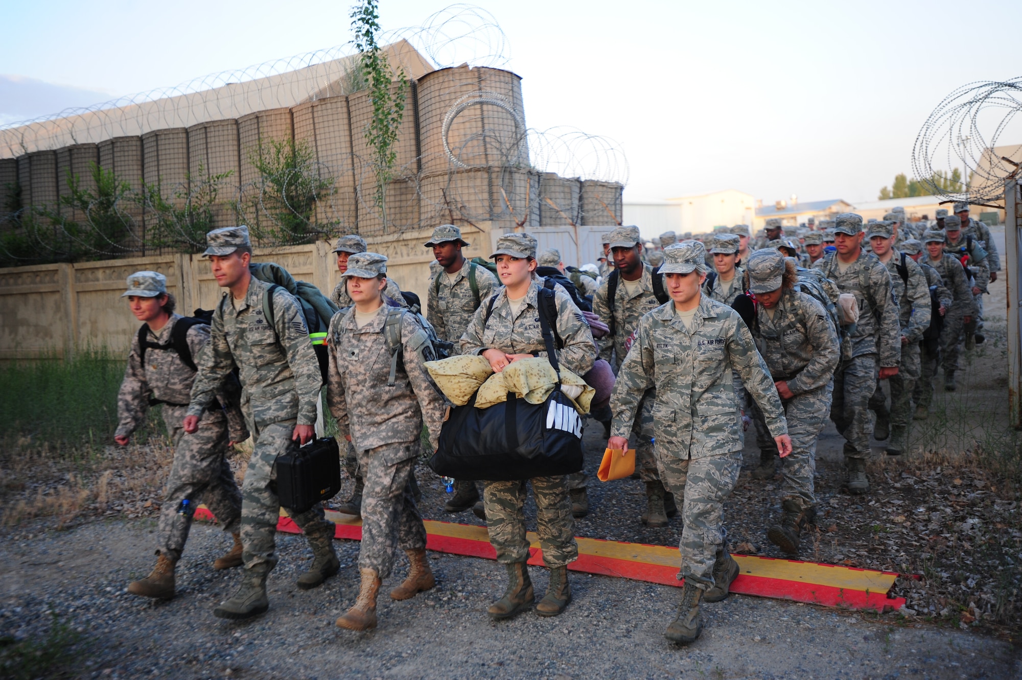 Shouldering carry-on luggage and moving through an alternate gate, 182 Airmen and two Soldiers march their way from the Transit Center at Manas, Kyrgyzstan,  to the Manas International Airport tarmac and a waiting C-17 Globemaster III June 6, 2014.  The 5.3 million passengers who transited through the center over the last 12 years typically rode buses along the same route. (U.S. Air Force photo/Lt. Col. Max Despain)