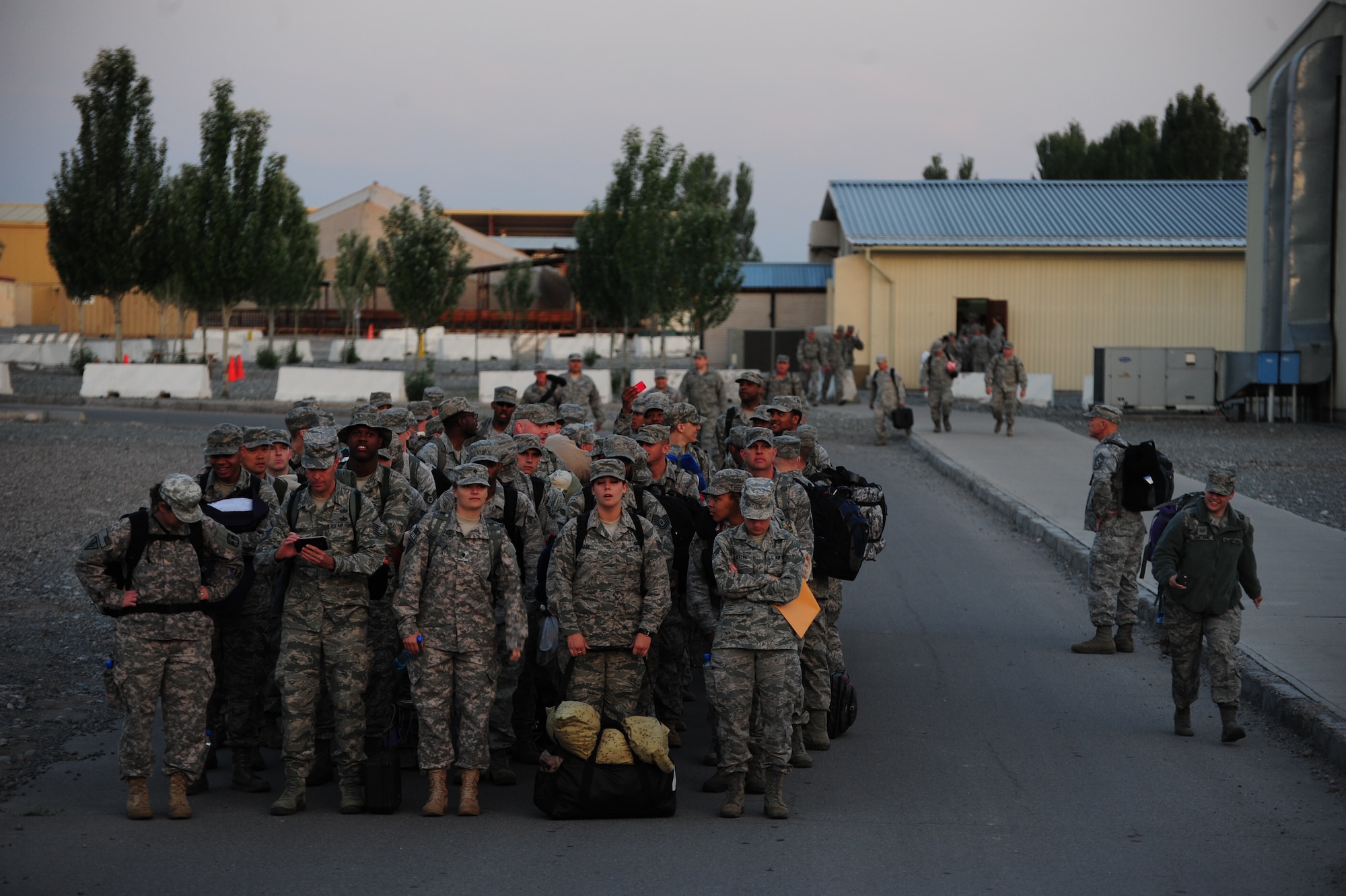 Airmen and the two remaining Soldiers from the Transit Center at Manas, Kyrgyzstan, start making a formation June 6, 2014.  Once all 184 service members were accounted for, the group marched for about 15 minutes, singing jodies as they made their way to the Manas International Airport flight line and a waiting C-17 Globemaster III.  These final Liberandos closed down the Transit Center and began working their way home that day. (U.S. Air Force photo/Lt. Col. Max Despain)