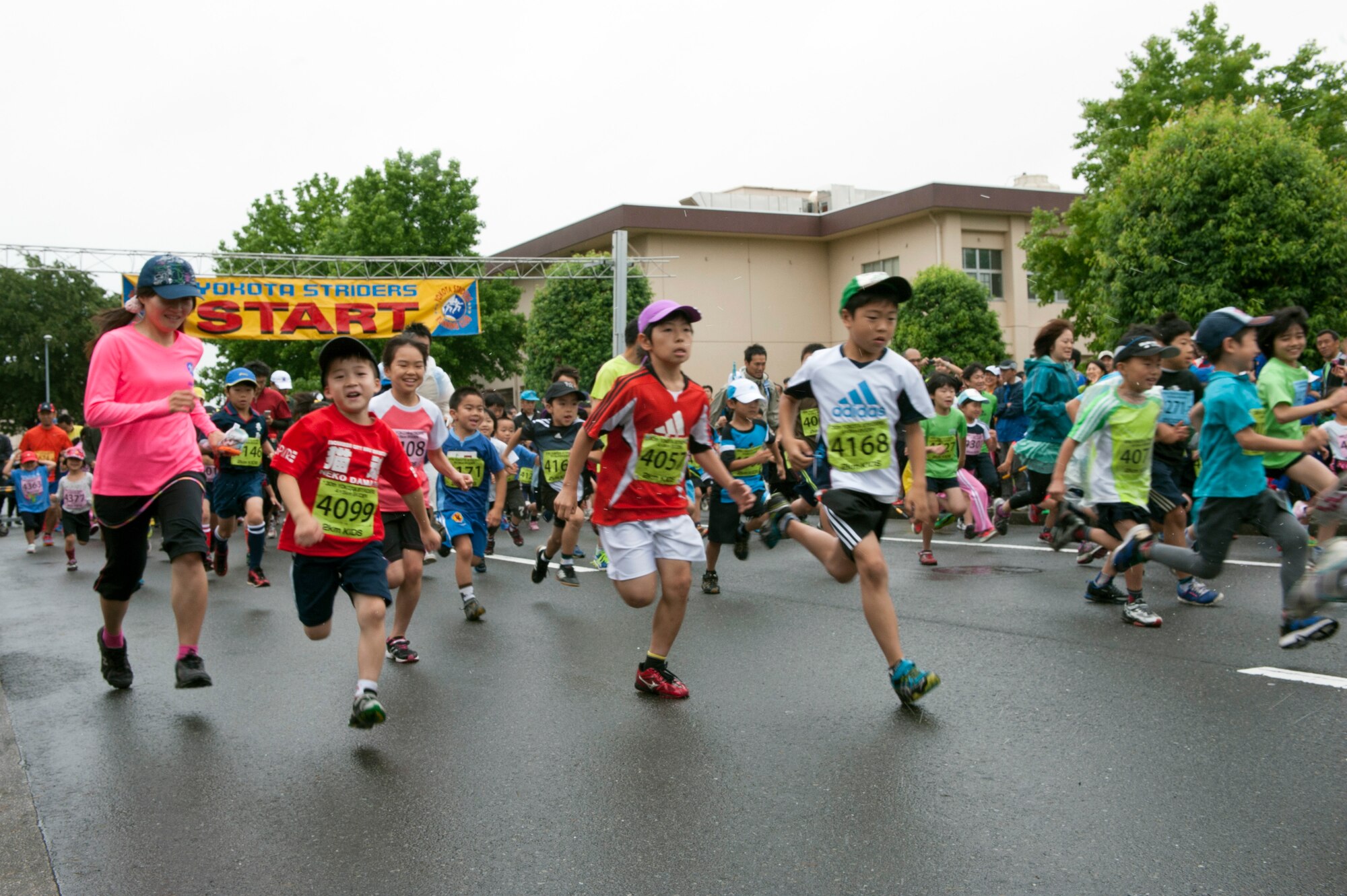 Runners participate in a group warm-up prior to running at the Ekiden June 8, 2014, at Yokota Air Base, Japan. The annual road race is hosted by the Yokota Strider’s, a private organization at Yokota. (U.S. Air Force photo by Senior Airman Desiree Economides/Released)