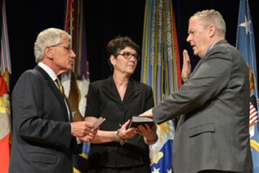 Defense Secretary Chuck Hagel, left, administers the oath of office to newly installed Deputy Defense Secretary Bob Work during a welcome ceremony at the Pentagon, June 9, 2014.