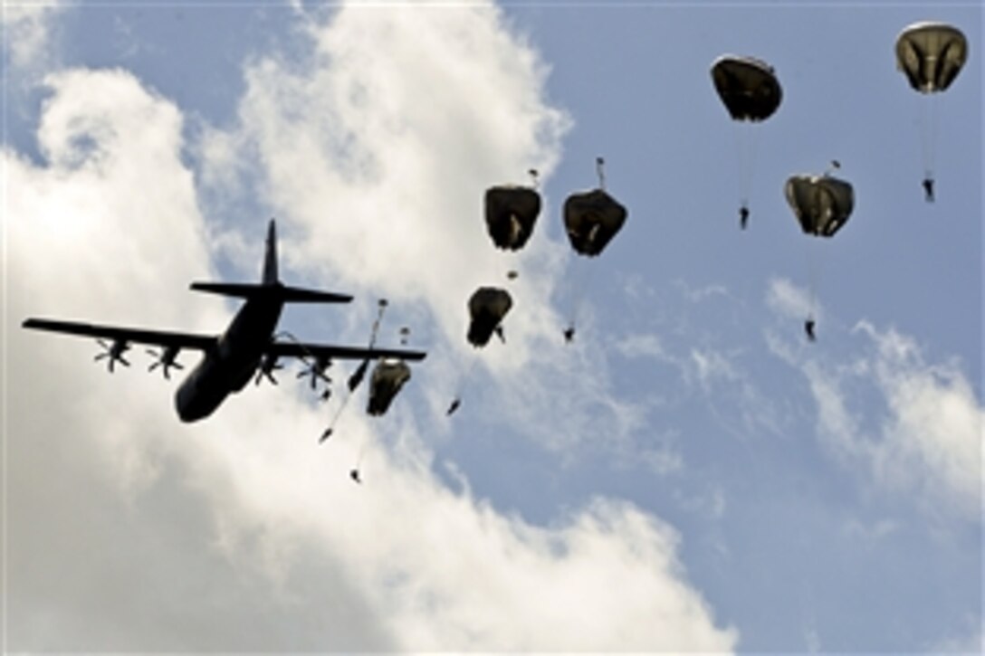 A U.S. Air Force C-130 Hercules aircraft drops U.S. and international paratroopers to commemorate the 70th anniversary of D-Day in Normandy, France, June 8, 2014. More than 700 paratroopers from the United States, France, Germany, England and the Netherlands re-enacted the historic airdrop over the town of Chef-du-Pont, France.